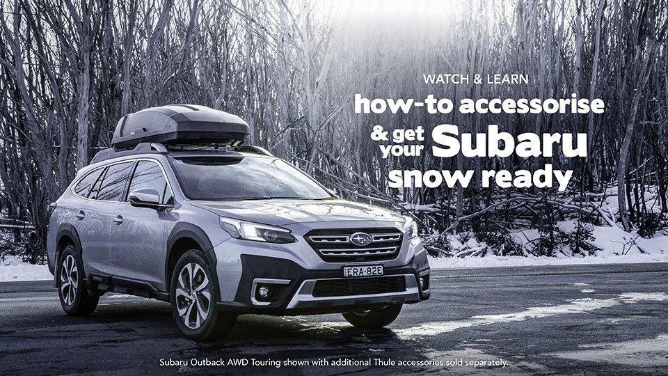 Silver Subaru with pod on roof and accessories in snow